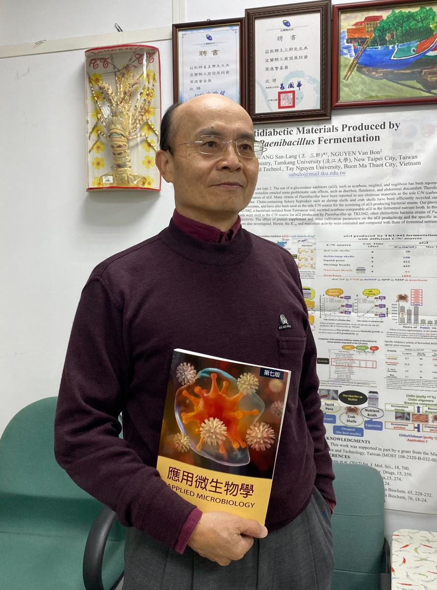 圖1：三郎老師與其近30年研究心血第七版『應用微生物學』(林珮霖攝）